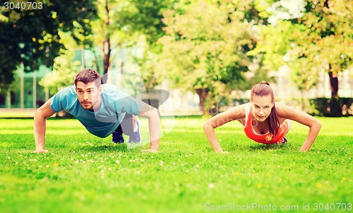 Image of couple doing push-ups outdoors