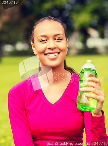 Image of smiling teenage girl showing bottle