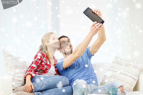 Image of smiling couple with tablet pc computer at home