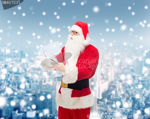 Image of man in costume of santa claus with notepad