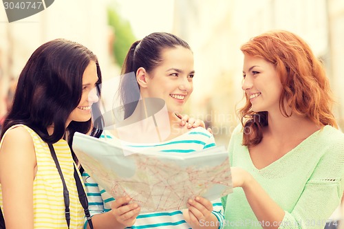 Image of smiling teenage girls with map and camera