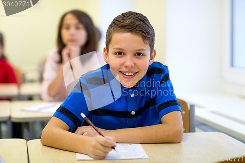 Image of group of school kids writing test in classroom