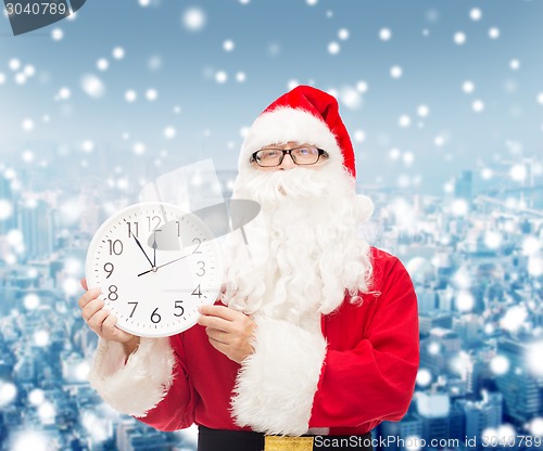 Image of man in costume of santa claus with clock