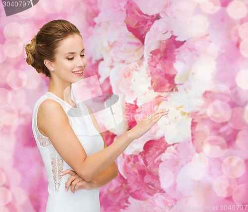 Image of smiling woman in white dress with diamond ring