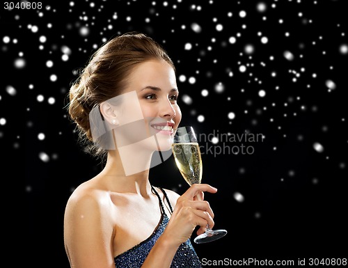 Image of smiling woman holding glass of sparkling wine