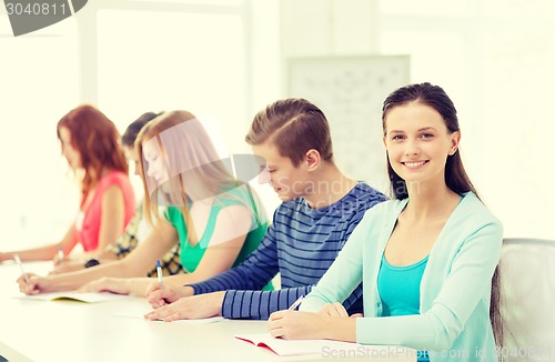 Image of smiling students with textbooks at school