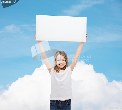 Image of smiling little girl holding blank white board