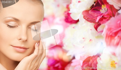 Image of beautiful young woman touching her face