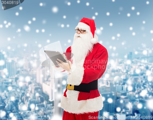 Image of man in costume of santa claus with tablet pc