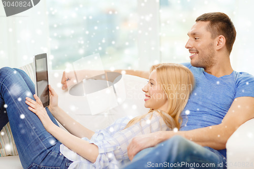 Image of smiling happy couple with tablet pc at home