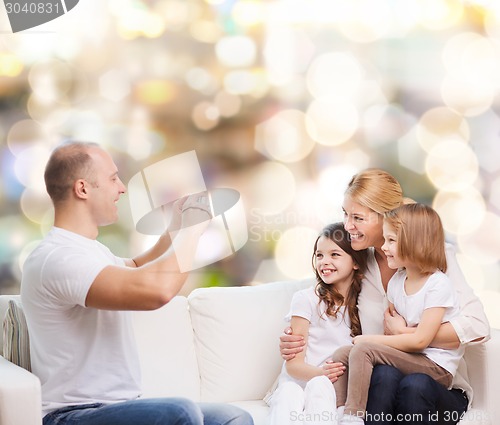 Image of happy family with camera at home