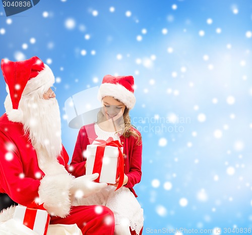 Image of smiling little girl with santa claus and gifts
