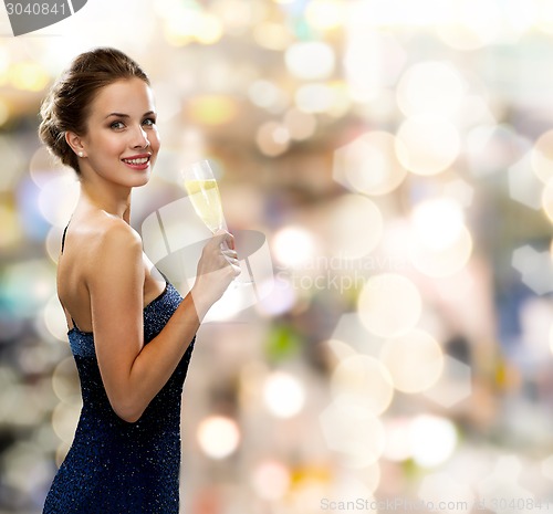 Image of smiling woman holding glass of sparkling wine