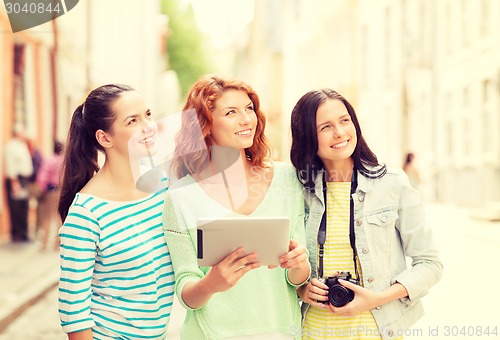 Image of smiling teenage girls with tablet pc and camera