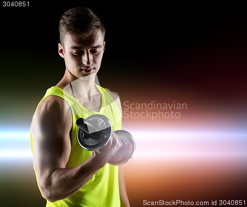 Image of young man with dumbbell flexing biceps