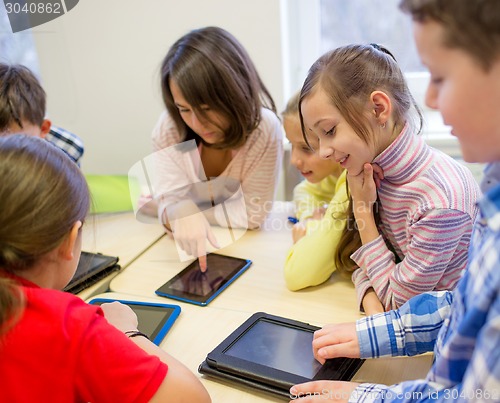 Image of group of school kids with tablet pc in classroom