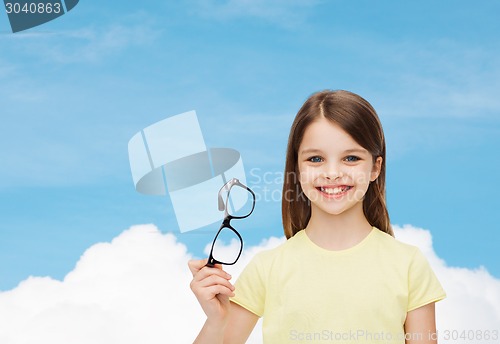 Image of smiling cute little girl holding black eyeglasses