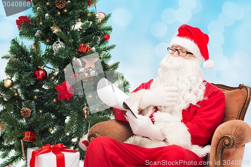 Image of man in costume of santa claus with notepad