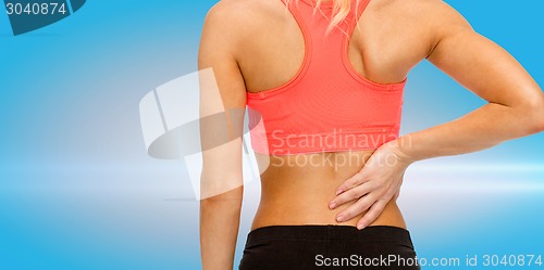 Image of close up of sporty woman touching her back