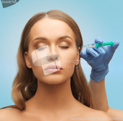 Image of beautiful woman face and hand with syringe