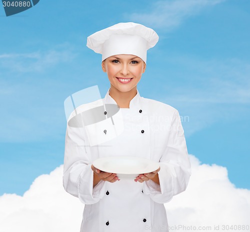 Image of smiling female chef with empty plate