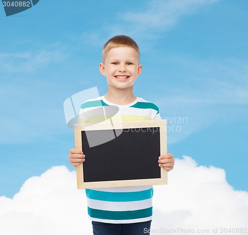 Image of smiling little boy holding blank black chalkboard
