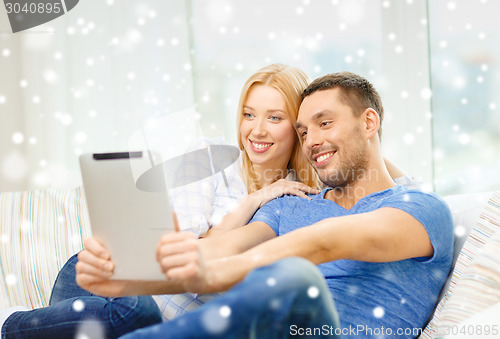 Image of smiling happy couple with tablet pc at home