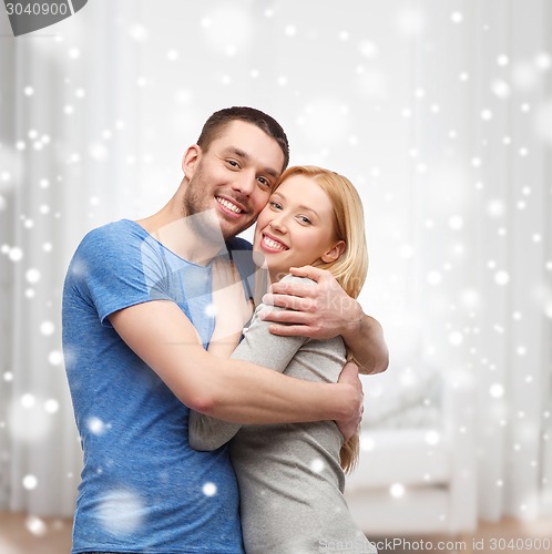 Image of happy couple hugging at home