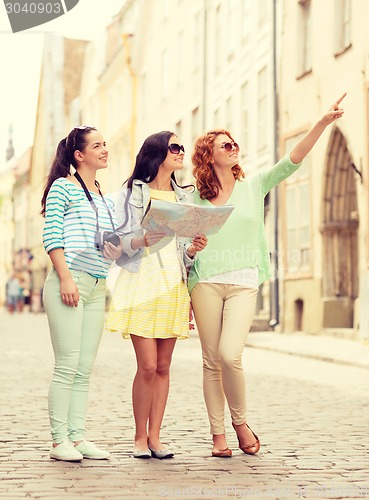 Image of smiling teenage girls with map and camera