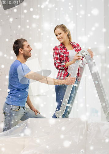 Image of smiling couple with ladder at home