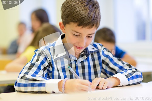 Image of group of school kids writing test in classroom