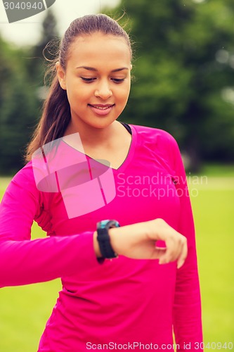 Image of smiling young woman with heart rate watch