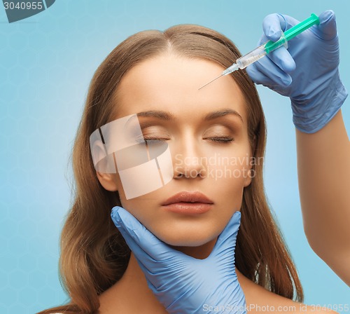 Image of beautiful woman face and hands with syringe