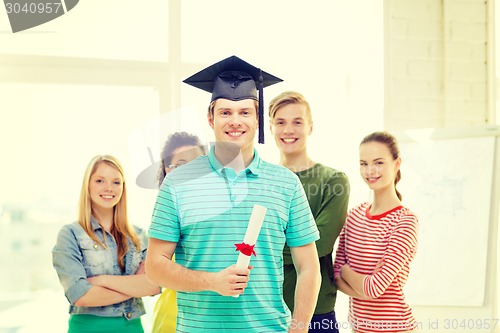Image of smiling male student with diploma and corner-cap