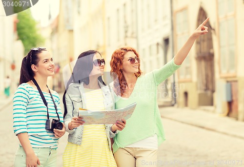 Image of smiling teenage girls with map and camera