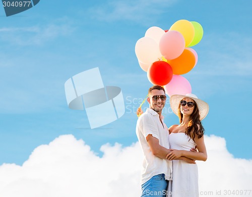 Image of smiling couple with air balloons outdoors