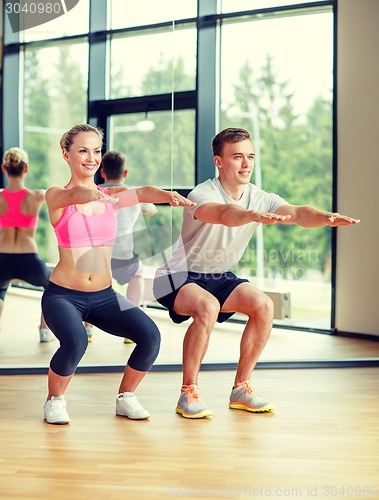 Image of smiling man and woman in gym