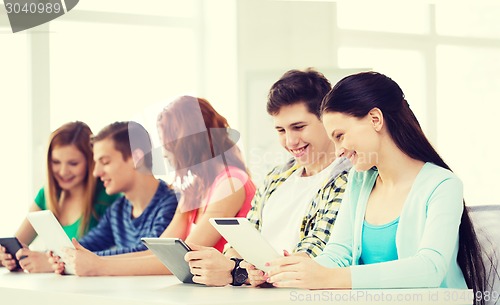 Image of smiling students with tablet pc at school