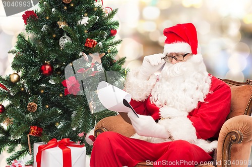 Image of man in costume of santa claus with notepad