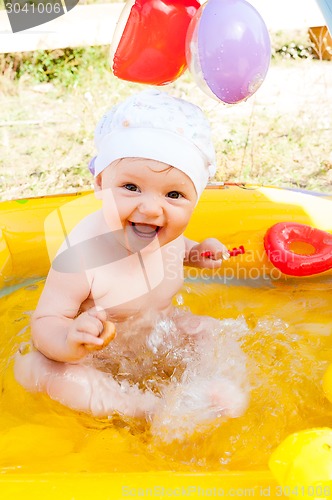 Image of Little 9 monthes old girl swims in pool