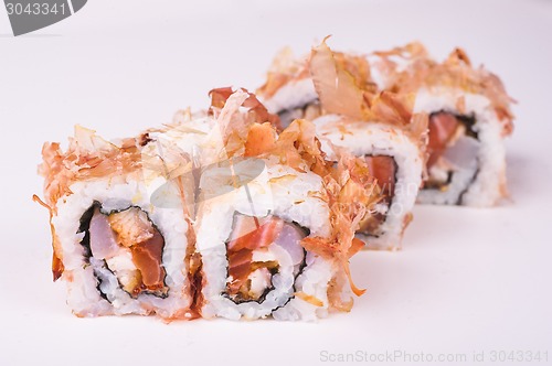 Image of salmon sushi roll in tuna flakes 