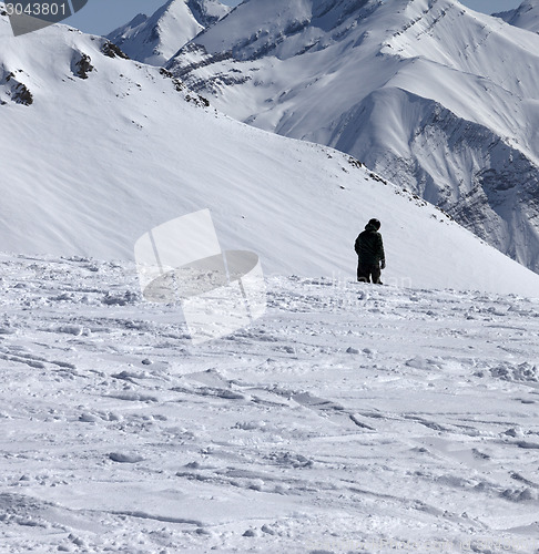 Image of Ski trail and snowboarder in sun winter day