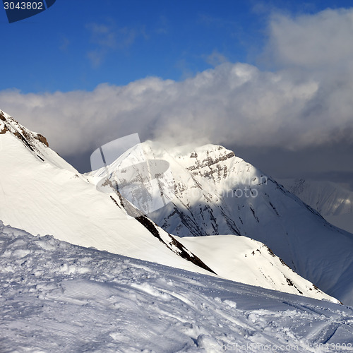 Image of Off-piste slope and sunlit mountains at evening