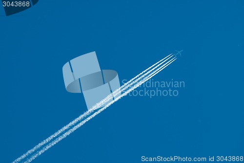 Image of Flying plane and inversion trace from engines