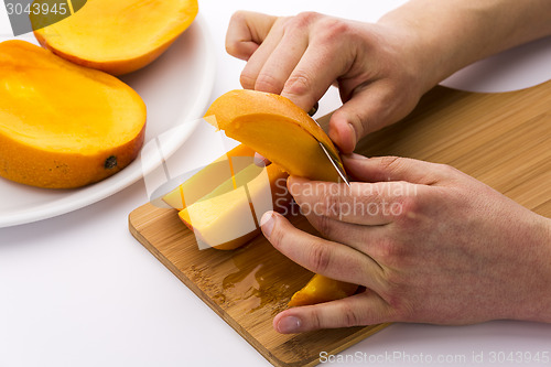 Image of Two Male Hands Peeling A Juicy Mango Fruit Chip