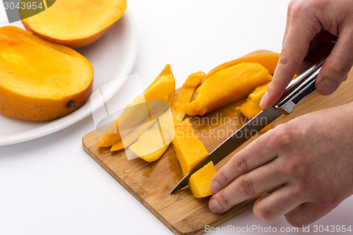 Image of Two Hands Dicing A Mango Wedge With A First Cut