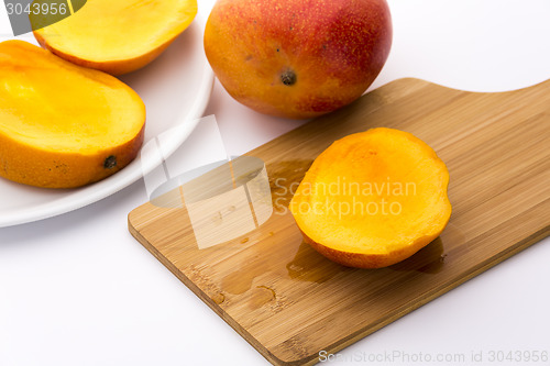 Image of Juicy Mango Slice On A Wooden Cutting Board