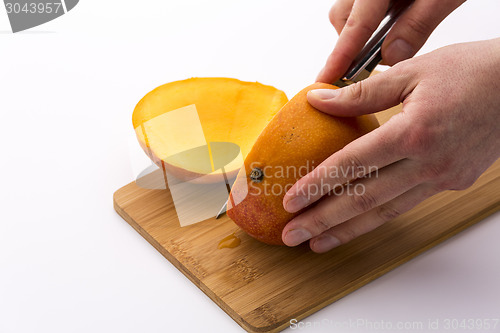 Image of Third Of A Mango Sliced Off In A First Cut