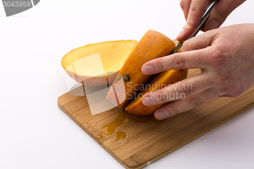 Image of Second Cut Through A Mango Does Yield Three Slices