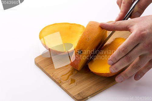 Image of Trisecting A Mango Along Its Flat, Oblong Pip